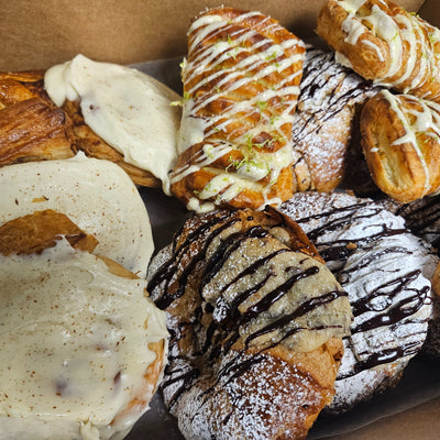 A catering tray of full-size pastries from the Radical Gardens bakery — glazed cinnamon buns with danishes, cookie croissants and raspberry crown pastries — Timmins