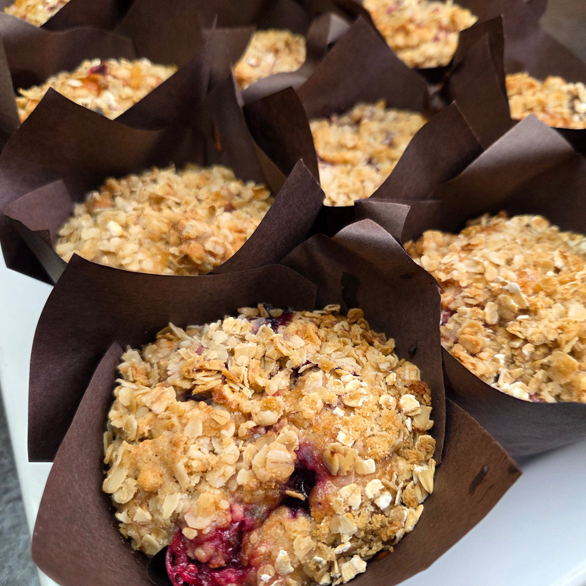 A dozen scratch-baked seasonal morning muffins, oatmeal and berry, wrapped and ready for pickup — Radical Gardens bakery, Timmins