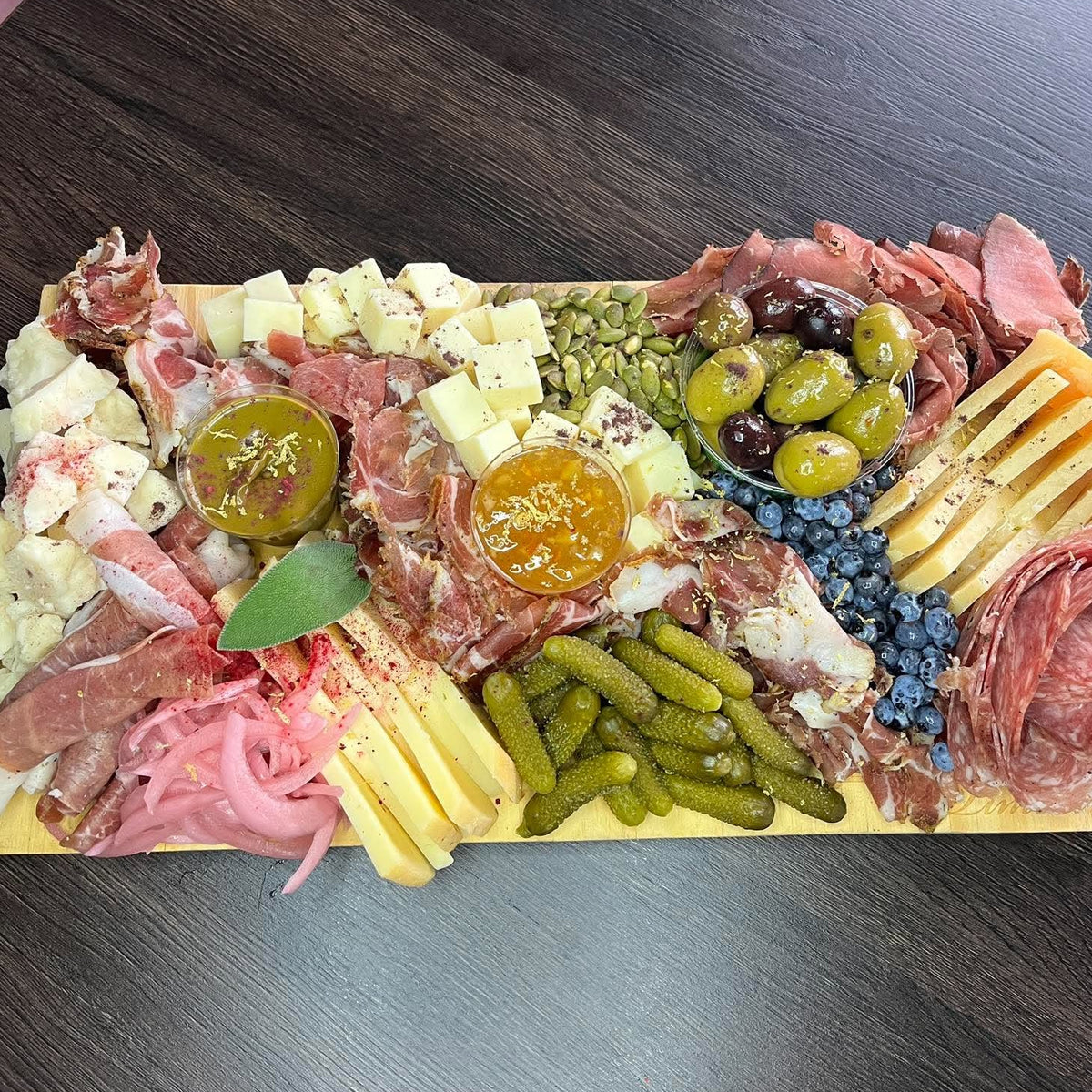 Charcuterie board of house-cured meats, artisan cheeses from Canada, Italy and Spain, pickles and house-made dips, displayed on a wood board — Radical Gardens, Timmins