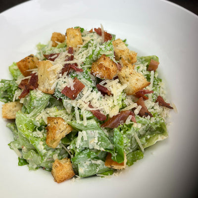 Catered Caesar salad bowl for 6 with crisp local romaine, scratch-made dressing on the side, house-made croutons, local bacon and grated Parmesan — Radical Gardens, Timmins